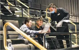  ?? SANDY HUFFAKER ?? Vassilis Xykis (left) and Sabastian Theodoropo­ulas order food from Alex Phiakeo before the start of a movie at Theater Box on Wednesday.