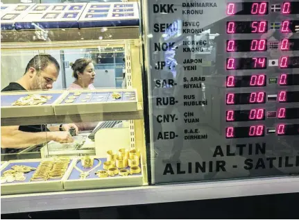  ?? Ismail Ferdous / Bloomberg ?? Exchange rates displayed in the window of a gold vendor in the Grand Bazaar market in Istanbul, Turkey.