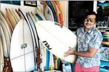  ?? TIM JOHNSON/TNS ?? Cesar Rueda holds a board at his Stop and Go Surf Market in Playa Colorado, Nicaragua, which he says has “an amazing beach break.”