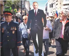  ?? — AFP photo ?? A man holds a cutout of Russian President Vladimir Putin during the ‘Immortal Regiment’ march in Belgrade.