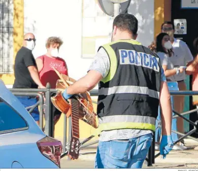  ?? MANUEL ARANDA ?? Un policía lleva una guitarra con la que, al parecer, fue golpeada la víctima.