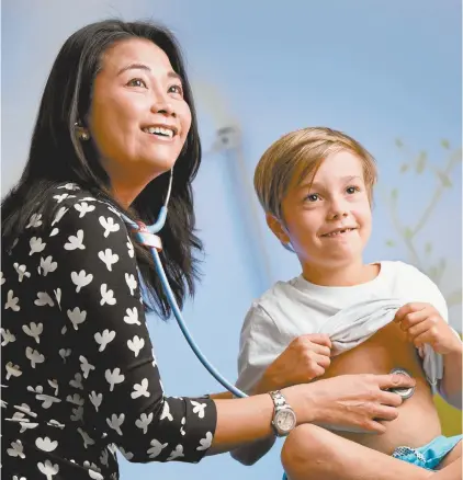  ??  ?? Professor Mimi Tang with a young patient.
