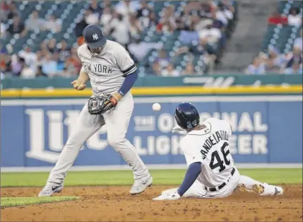  ?? Paul Sancya / Associated Press ?? Yankees second baseman Gleyber torres can’t handle a throw as the tigers’ Jeimer Candelario slides into second base in the third inning tuesday night at Comerica Park. torres was charged with an error on the play.