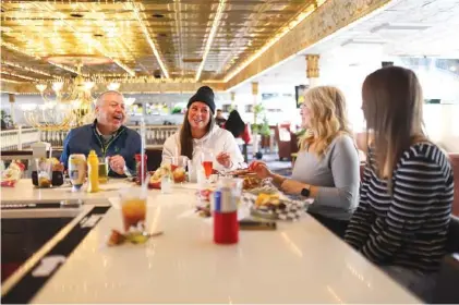  ?? STAFF PHOTOS BY OLIVIA ROSS ?? From left, Paul Rushing, Isabellah Knarr, Bridgett Crumbley and Heidi Rushing eat lunch at the Southern Belle Riverboat’s Burger Bar on Sunday. The Burger Bar has moved from the third floor to the second, with new furnishing­s. The third floor is now a private event space.