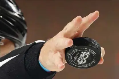  ?? —AFP ?? NEWARK: A linesman prepares to drop a 100th anniversar­y of the NHL puck during the game between the New Jersey Devils and the Washington Capitals at the Prudential Center on Monday in Newark, New jersey.