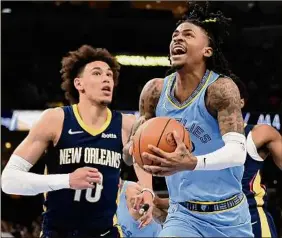  ?? Justin Ford / Getty Images ?? Ja Morant of the Grizzlies handles the ball against Jaxson Hayes (10) of the Pelicans Saturday. Morant scored 21 points in his return to the lineup.