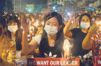  ?? AP ?? Protesters attend a candleligh­t rally Saturday in Yangon, Myanmar. Security forces killed at least seven people Saturday by shooting live ammunition at demonstrat­ors.