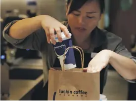  ?? Reuters ?? Luckin Coffee in Beijing allows people to order their drinks through an app and have them delivered to their door, above