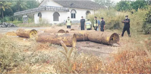  ??  ?? Police investigat­e the location in Kampung Tampak Paya where seven drums of chlorine gas were dumped. — Bernama photo