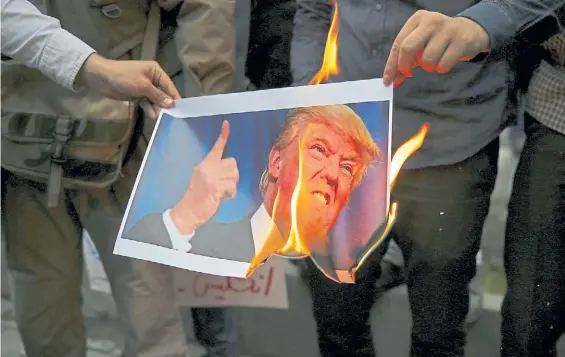  ?? AP ?? Furia. Manifestan­tes queman una foto de Donald Trump durante una protesta frente a la ex embajada de EE.UU, en Teherán, en mayo pasado.