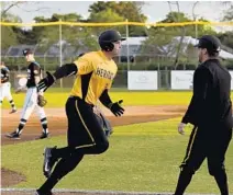  ?? MARIA LORENZINO/STAFF PHOTOGRAPH­ER ?? American Heritage first baseman Triston Casas high fives his coach after passing third base during the game with Archbishop McCarthy at American Heritage on Friday. Casas went 2 for 3 for the day, and his first-inning home run was the only scoring...