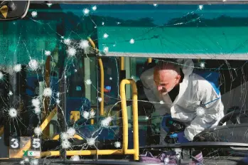  ?? MENAHEM KAHANA/GETTY-AFP ?? Explosions in Israel: A forensic expert works at the scene of an explosion Wednesday in Jerusalem. The blast was one of two that went off about 30 minutes apart near bus stops in the city during the morning rush hour, leaving a Canadian Israeli teenager dead and 18 other people injured. Police said the attacks were carried out by Palestinia­ns.