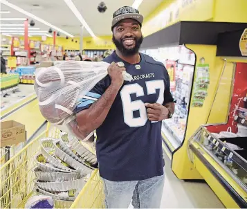  ?? JUSTIN GREAVES TORSTAR FILE PHOTO ?? Jamal Campbell hands out turkeys at Toronto’s Yorkgate Mall in October 2019. Growing up, the Toronto Argonauts offensive lineman’s family sometimes had to go to a food bank or accept donations to ensure there was enough to eat. Campbell and his three siblings were raised by their single mother — who worked two jobs trying to make ends meet.