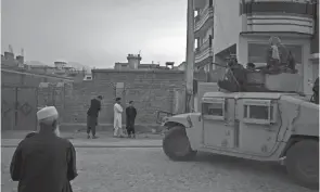  ?? FELIPE DANA/AP ?? Afghans watch as Taliban fighters ride atop a humvee after detaining four men involved in a street fight in Kabul, Afghanista­n, Sept. 21.