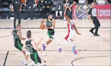  ?? MARK J. TERRILL— THE ASSOCIATED PRESS ?? Boston Celtics’ Jayson Tatum, center, drives against Miami Heat’s Andre Iguodala during the second half of an NBA conference final playoff basketball game Friday in Lake Buena Vista, Fla. The Celtics won 121-108.