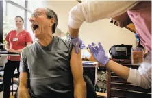  ?? Michael Macor / The Chronicle 2014 ?? Jean Pierre Pascal of Menlo Park feigns pain as he gets a flu shot from Ginny To at a clinic in Redwood City in 2014.