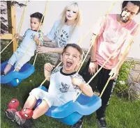  ?? SUSIE KOCKERSCHE­IDT/METROLAND ?? Rafael Gutterres, wife Danieli Lopez and four-year-old twins Kevin, left, and Kyle enjoy playing on the swings as a family.