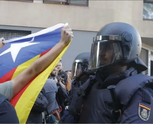  ?? Barcelona. © Gtres/belga ?? Spaanse agenten, wapen in de aanslag, proberen de demonstran­ten in de hand te houden bij het hoofdkwart­ier van de linkse Catalaanse partij CUP in