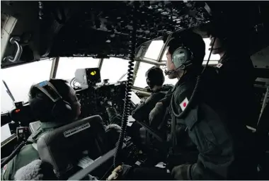  ?? KOJI UEDA/ ASSOCIATED PRESS FILES ?? Flight crew aboard a Japanese Self-Defence Force C130 aircraft scour the southeaste­rn Indian Ocean for Flight 370.