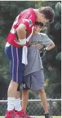  ?? STAFF PHOTOS BY NANCY LANE ?? REWARD FOR A HARD DAY’S WORK: Tom Brady loads up to fire a pass in a drill during yesterday’s sweltering Patriots training camp session, and afterward gives a hug to his oldest son, Jack.