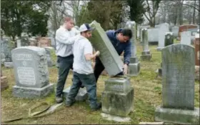  ?? JIM SALTER — THE ASSOCIATED PRESS ?? Rosenbloom Monument Co. workers from left, Nathan Fohne, Derek Doolin and Philip Weiss hoist a headstone at the Chesed Shel Emeth Cemetery in University City, Mo., where over 150 headstones were tipped over. The cemetery is getting a show of support...