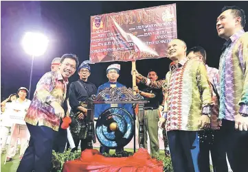  ??  ?? Dr Sim (left) striking the gong seven times to officiate at the CASH Martial Arts Display 2017 event. Looking on are Chan (second right) and Azizi (far right).