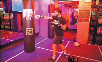  ?? — Reuters ?? A gym instructor punches a boxing bag containing an image of Boris Johnson during a Brexfit gym class at Gym Box in London.