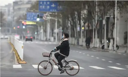  ?? Photograph: Stringer/Getty Images ?? ‘Between the beginning of the year and the lockdown, five million people left Wuhan for destinatio­ns in China and beyond.’ Cyclist in Wuhan, China, 27 January 2020.