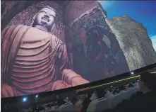  ?? CHEN BIN / XINHUA ?? Visitors watch a full- dome film at Mogao Grottoes Visitor Center in Dunhuang, Gansu province, on March 18.