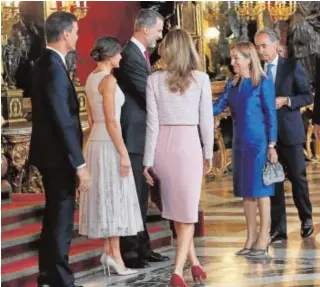  ??  ?? Sánchez y su esposa se sitúan junto a los Reyes y tienden su mano a la presidenta del Congreso, el pasado viernes en el Palacio Real