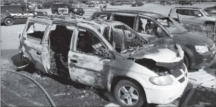  ?? DAVID JOLES/STAR TRIBUNE VIA AP ?? This Tuesday photo, shows two charred vehicles in the parking lot of a Walmart in Fridley, Minn.