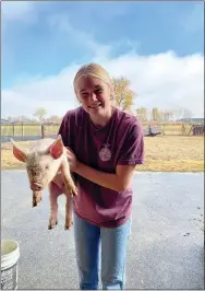 ?? ?? FFA Ellen Slater, an FFA student, holds a pig that she is working with.