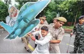  ?? PHOTO:PTI ?? Police detain a protester carrying a model of a plane during a protest over the Rafale deal issue outside the AICC office in New Delhi on Saturday