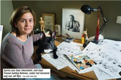  ?? Foto KRIS VAN EXEL ?? Sarina aan haar tekentafel, met haar Franse buldog Batman, onder het toeziend oog van Jef Nys.