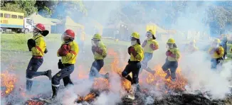  ?? Picture: SUPPLIED ?? IN TRAINING: Firefighte­rs run through a fire during their Yellow Card training held in Witelsbos earlier this month.