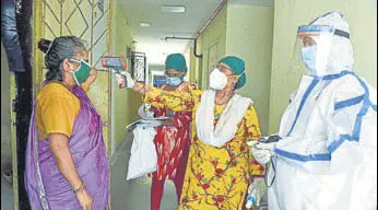  ?? SATISH BATE/HT PHOTO ?? A BMC health worker checks the temperatur­e of a resident in Khar, Mumbai.