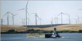  ?? RICH PEDRONCELL­I — THE ASSOCIATED PRESS FILE ?? A tugboat pushes a barge down the Sacramento River past wind turbines near Rio Vista.