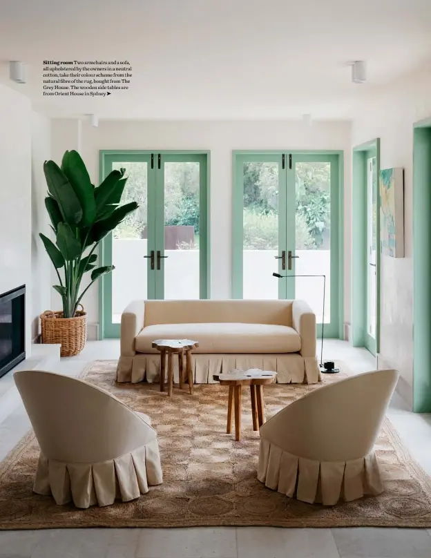  ??  ?? Sitting room Two armchairs and a sofa, all upholstere­d by the owners in a neutral cotton, take their colour scheme from the natural fibre of the rug, bought from The Grey House. The wooden side tables are from Orient House in Sydney