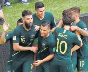  ?? REUTERS ?? Australia captain Mile Jedinak (No 15) is congratula­ted by teammates after he scored off a penalty to equalise against fancied opponents Denmark in Samara on Thursday.