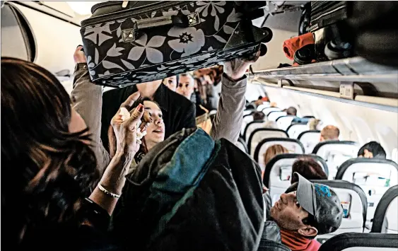  ?? ROBERT NICKELSBER­G/GETTY ?? United passengers who book basic economy fares typically aren’t allowed to bring a full-sized carry-on bag aboard the plane.