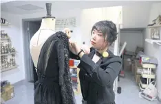  ?? ?? ABOVE
Costume designer Zhang Yifan works on an outfit she designed for her sister, figure skater Zhang Yixuan, at her studio in Beijing.