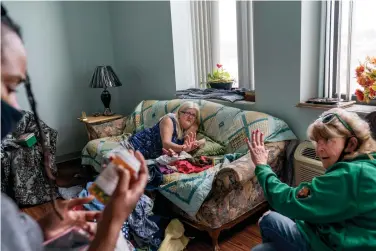  ?? AP Photo/David Goldman ?? Sue Howland, right, and Larrecsa Cox, left, members of the Quick Response Team, help Betty Thompson, 65, who struggles with alcohol addiction, count her medication­s March 17 at her apartment in Huntington, W.Va. Thompson called that morning to say she needed help. With preexistin­g conditions that make her especially vulnerable to COVID, she'd been terrified she'd get the virus and die, and so she's drank more these months than she ever has before.