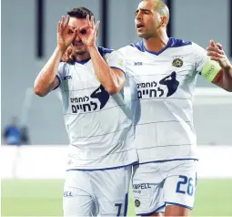  ?? (Danny Maron) ?? MACCABI TEL AVIV forward Omer Atzili (left) celebrates with teammate Tal BenHaim after scoring his team’s opener in last night’s 2-0 victory over Bnei Yehuda.