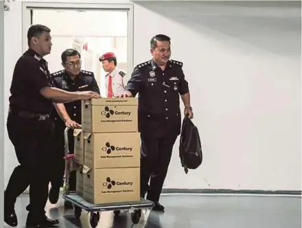  ?? PIC BY SYARAFIQ ABD SAMAD ?? Police carting away boxes of documents seized from Deloitte Malaysia’s office in Kuala Lumpur yesterday.