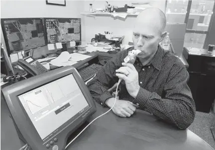  ?? ALGERINA PERNA/BALTIMORE SUN ?? Robert M. Reed, a professor of medicine at the University of Maryland, demonstrat­es the use of a spirometer, which measures lung function. His study of members of Pennsylvan­ia’s Amish community showed the effects of secondhand smoke on nonsmokers in...