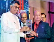  ??  ?? Tharanga Land Sales Chairman Bandula Karunarath­ne receiving award from Minister Champika Ranawaka
