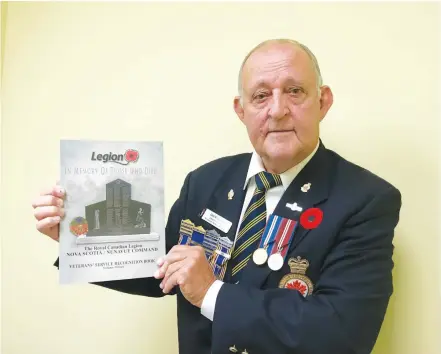 ?? ERIC BOURQUE ?? Don McCumber, poppy/remembranc­e chairman for the Royal Canadian Legion Nova Scotia/Nunavut Command, with the most recent edition of the Veterans’ Service Recognitio­n Book.