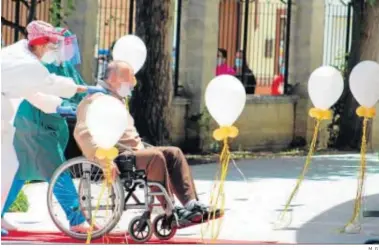  ?? M. G. ?? Dos sanitarios ayudan a un usuario de un geriátrico a acceder a la residencia.