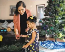  ?? Jessica Christian / The Chronicle ?? Rosa AlvizarGut­ierrez and daughter Lily, 1, decorate the tree at their home in Napa, thanks to a helping hand from the fund.