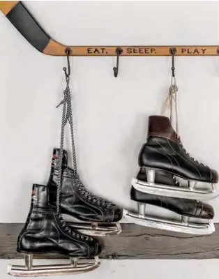  ??  ?? TOP, LEFT Throughout the space, open storage solutions like cubbies and hooks turn skate gear into decor. Made from a vintage-look hockey stick, this wall hook rack is a whimsical case in point.